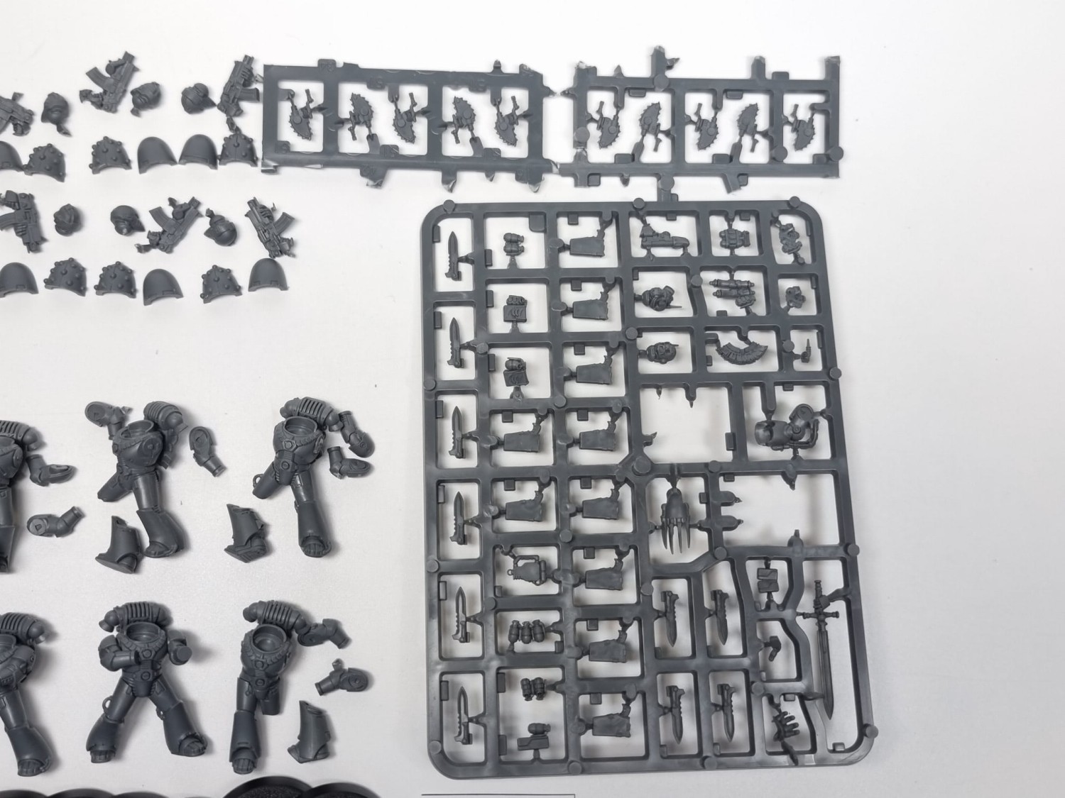 40k HH tactical marinesCzyste figurki 40k HH tactical marines na szarym tle i wypraska