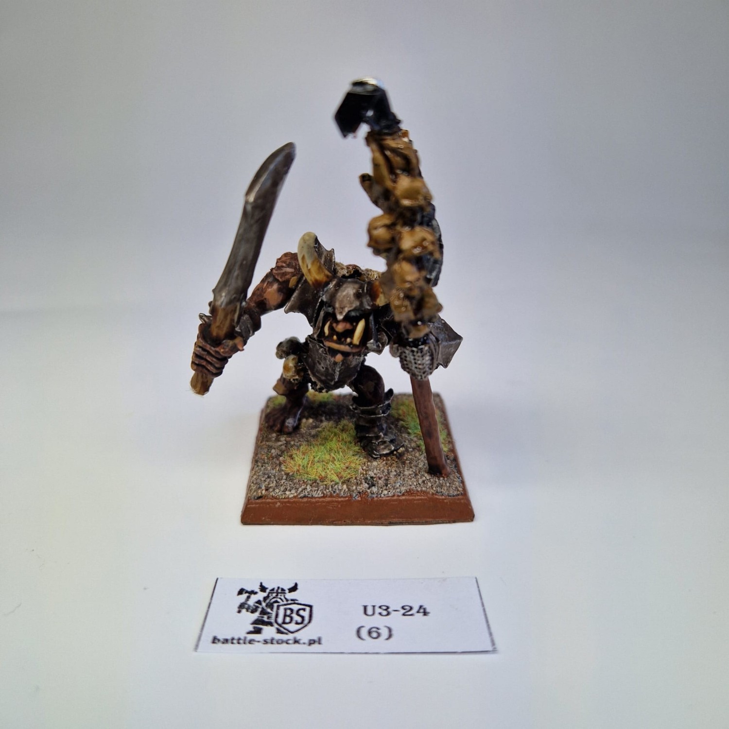 Figurka WFB Chaos Ogre na szarym tle.